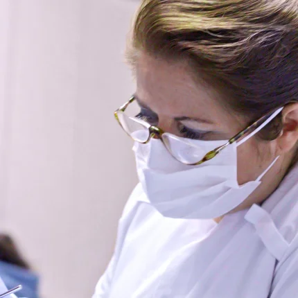 Image with a professional dentist attending to a patient.